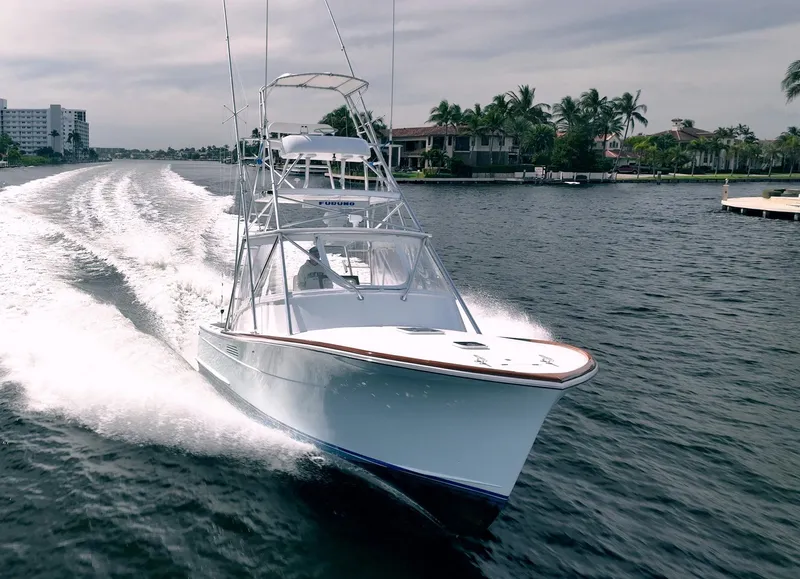 Slide: The Image of 1999 Gamefisherman 34 Express boat cruising on a scenic waterway. - 2