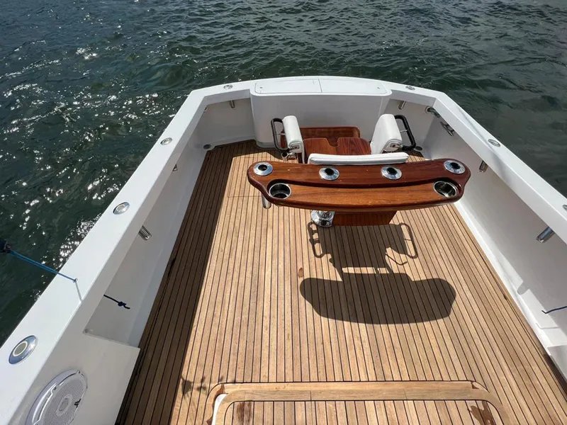 Slide: The Image of 1999 Gamefisherman 34 Express boat deck with wooden flooring and fishing chair. - 20