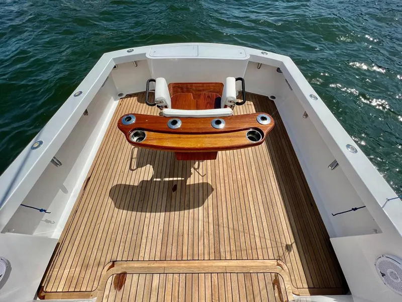 Slide: The Image of 1999 Gamefisherman 34 Express boat deck with wooden flooring and fishing chair. - 21