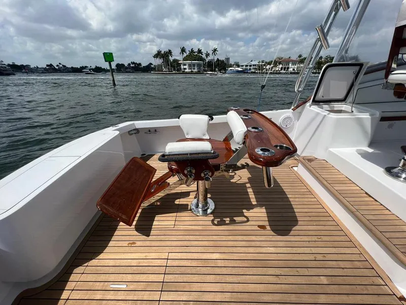 Slide: The Image of 1999 Gamefisherman 34 Express boat deck with fishing chair, rod holders, and teak flooring. - 25