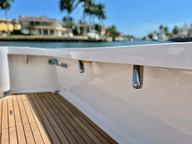 Slide: The Image of 1999 Gamefisherman 34 Express boat deck with wooden flooring, docked near waterfront homes. - 27