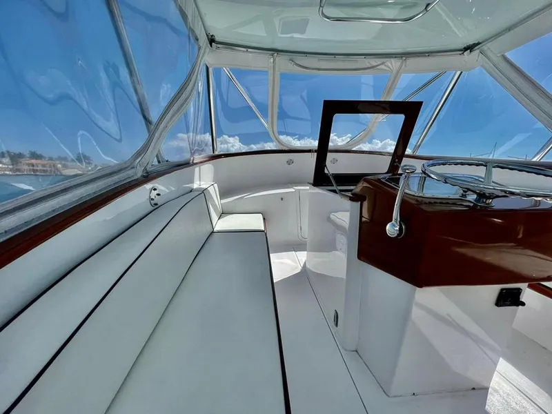 Slide: The Image of 1999 Gamefisherman 34 Express boat interior with white seating and wooden helm. - 5