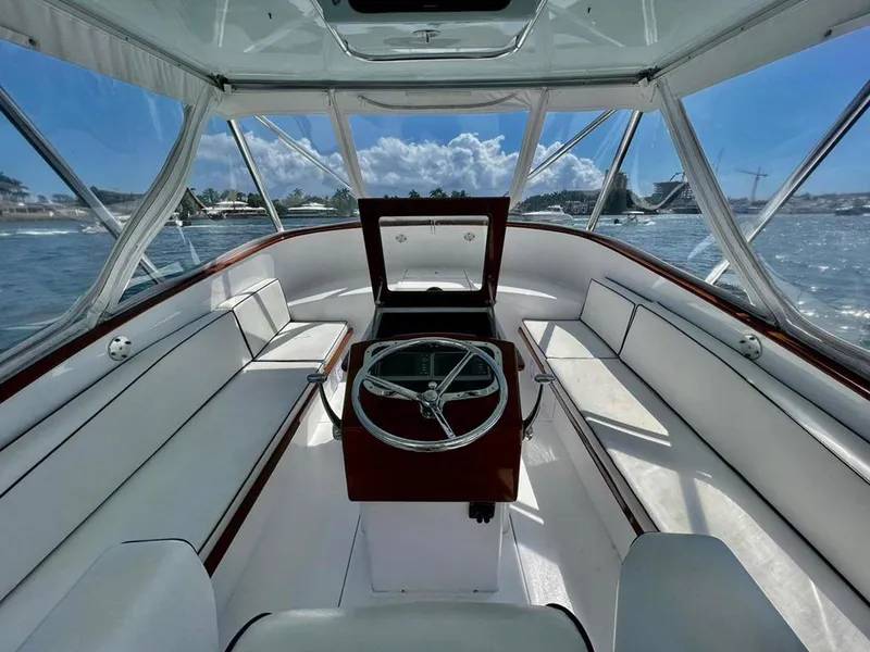 Slide: The Image of 1999 Gamefisherman 34 Express boat interior with white seating and steering wheel. - 8