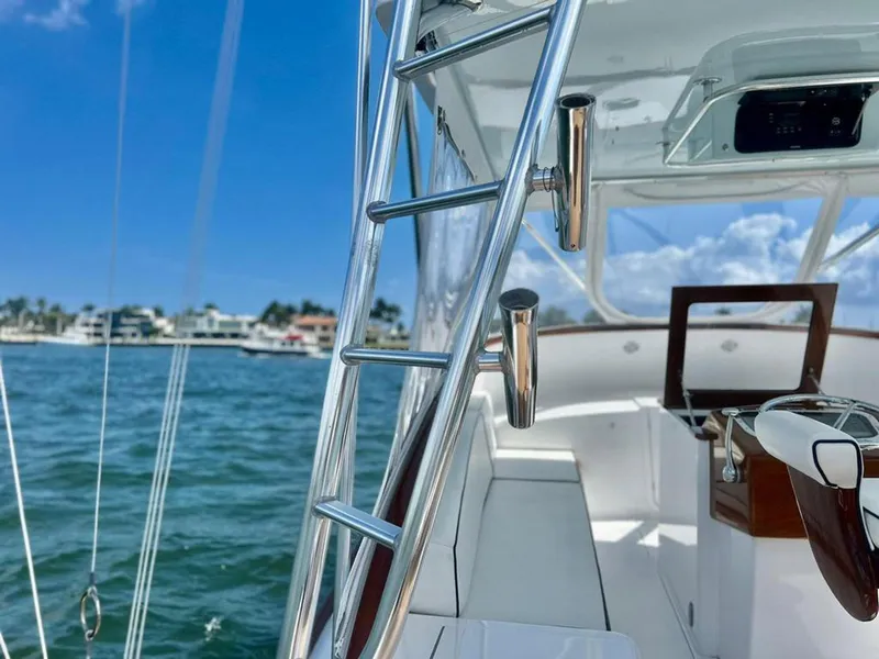 Slide: The Image of 1999 Gamefisherman 34 Express boat interior with ladder, ocean view, and clear blue sky. - 9