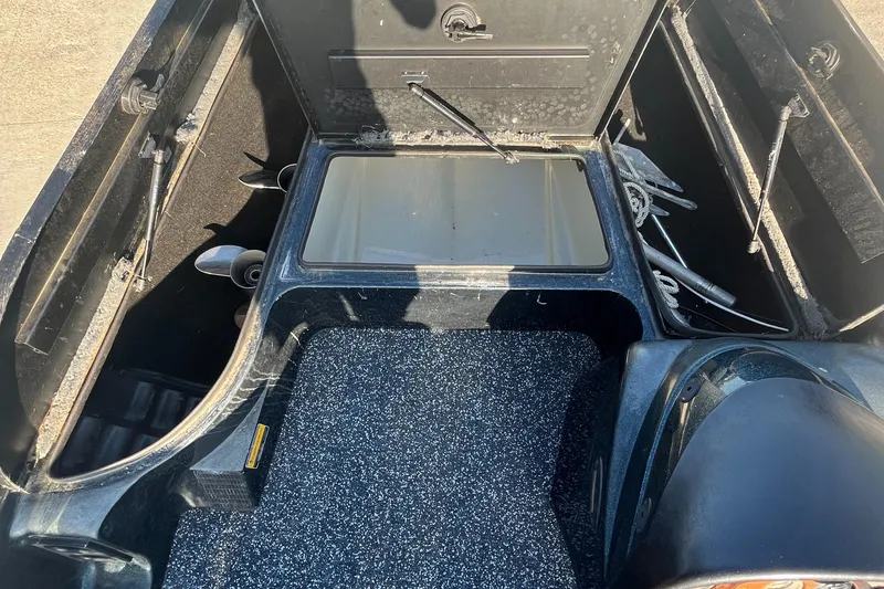 Slide: The Image of 1998 Triton Tr-17 boat interior with storage compartments and carpeted flooring. - 12