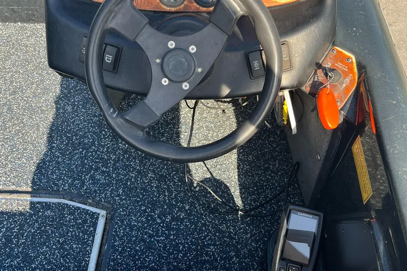 Slide: The Image of Steering wheel and dashboard of a 1998 Triton Tr-17 boat. - 13