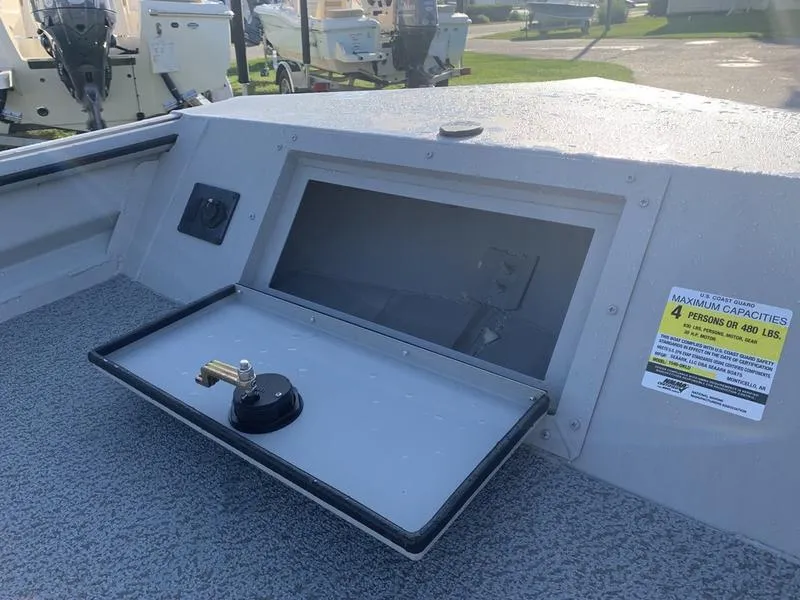 Slide: The Image of 2025 SeaArk DXS 1548 DKLD boat dashboard with storage compartment and capacity label. - 15