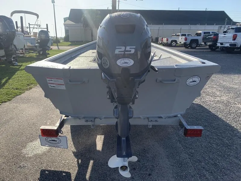 Slide: The Image of 2025 SeaArk DXS 1548 DKLD boat with 25 HP outboard motor, parked on a trailer. - 3