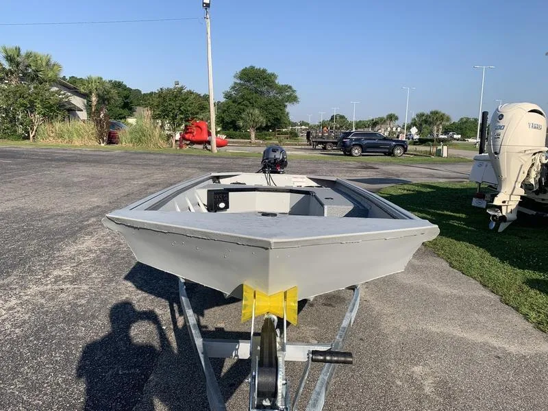 Slide: The Image of 2025 SeaArk DXS 1548 DKLD boat on trailer in sunny outdoor setting. - 7