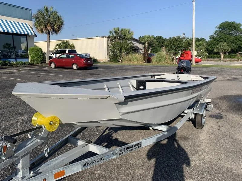 Slide: The Image of 2025 SeaArk DXS 1548 DKLD boat on trailer in parking lot, sunny day. - 8