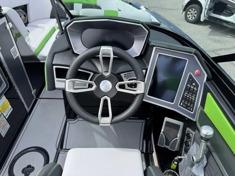 Slide: The Image of 2021 MasterCraft X24 boat dashboard with steering wheel and touchscreen controls. - 12