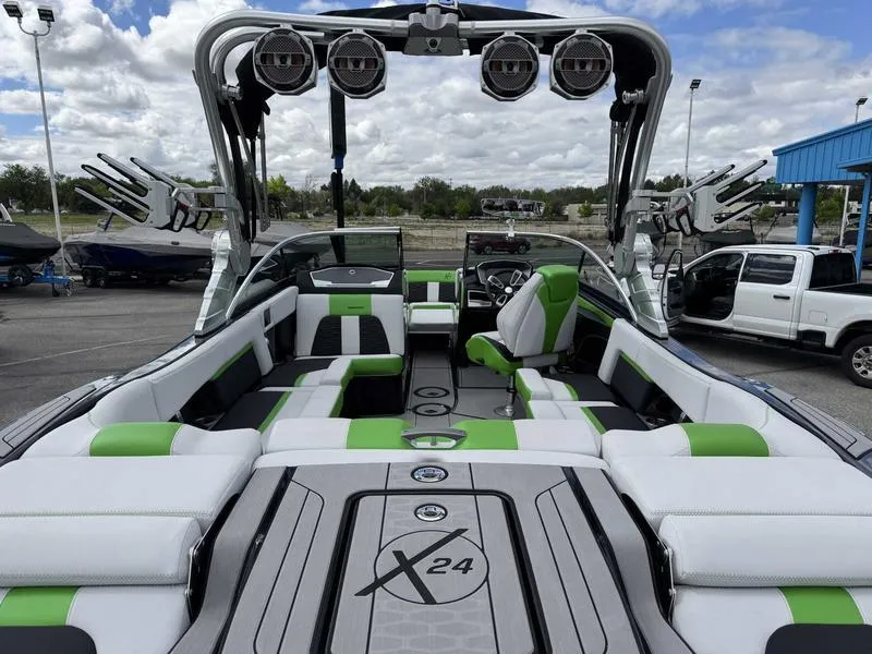 Slide: The Image of 2021 MasterCraft X24 boat interior with green and white seating, advanced sound system, and sleek design. - 8
