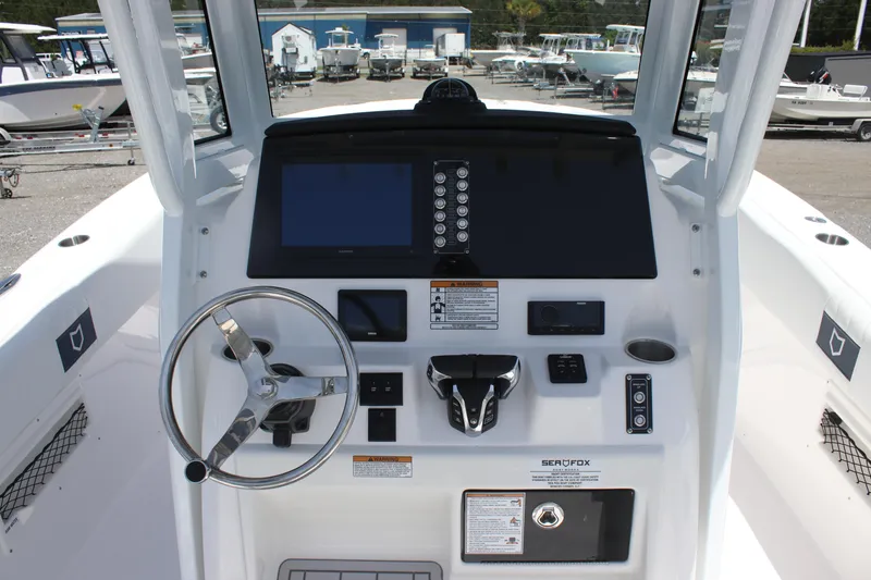 Slide: The Image of 2025 Sea Fox 268 Commander boat dashboard with steering wheel and electronic controls. - 11