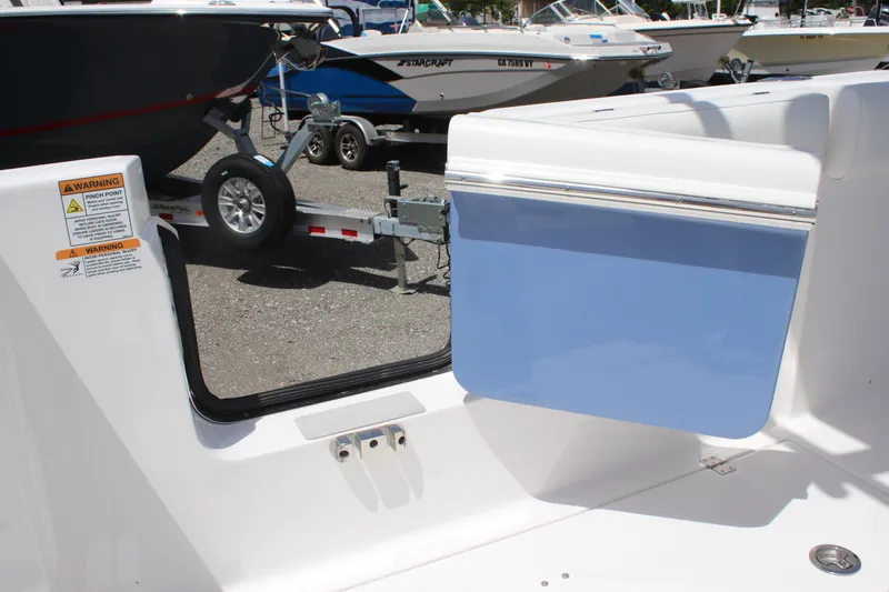 Slide: The Image of 2025 Sea Fox 268 Commander boat with open side door, trailer visible in background. - 18