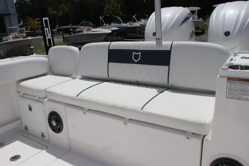 Slide: The Image of 2025 Sea Fox 268 Commander boat seating area with white cushioned bench and speaker. - 27
