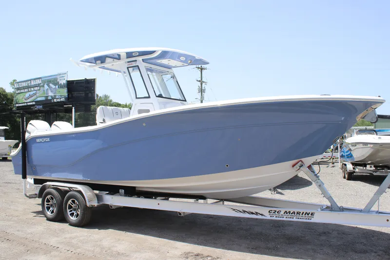 Slide: The Image of 2025 Sea Fox 268 Commander boat on trailer, blue hull, parked outdoors. - 6