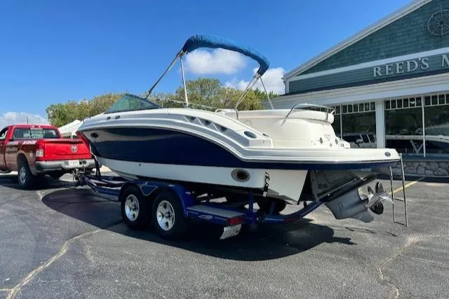 Slide: The Image of 2007 Chaparral SSX 236 boat on trailer, parked outside a building under a clear blue sky. - 2