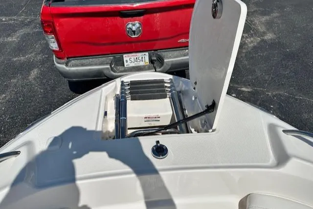 Slide: The Image of 2007 Chaparral SSX 236 boat with open storage compartment, parked near a red truck. - 20