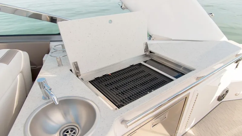 Slide: The Image of 2026 Regal 33 XO yacht kitchenette with sink and grill, featuring modern design and functionality. - 10