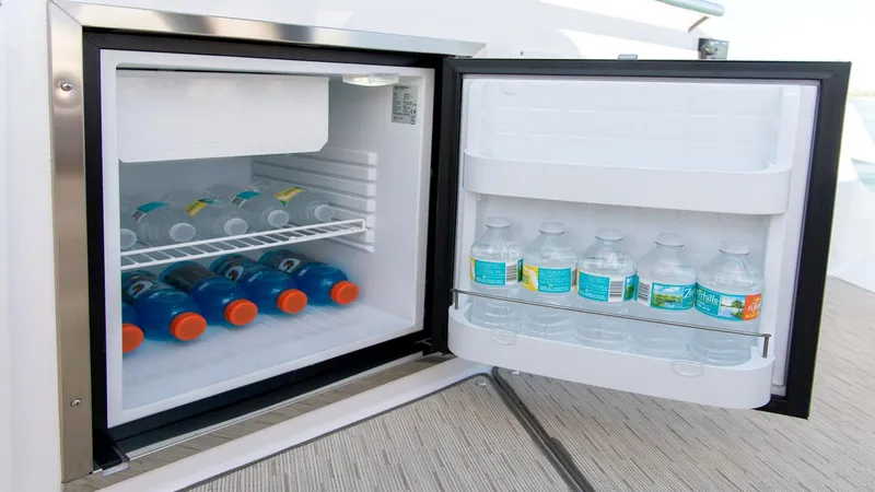 Slide: The Image of Mini fridge stocked with drinks on a 2026 Regal 33 XO boat. - 18