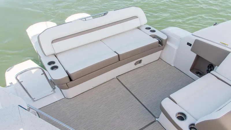 Slide: The Image of 2026 Regal 33 XO boat interior with cushioned seating and cup holders on deck. - 19