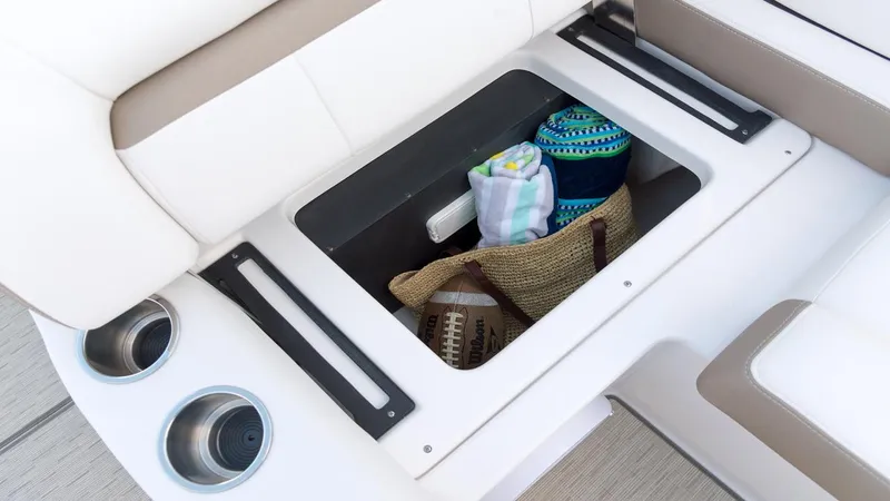 Slide: The Image of Storage compartment on 2026 Regal 33 XO boat with towels and a football. - 22