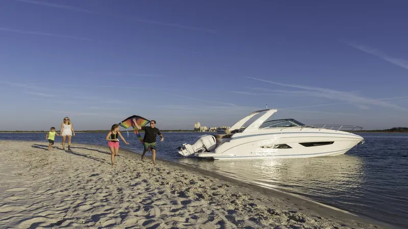 Slide: The Image of Family enjoying beach near 2026 Regal 33 XO boat. - 3
