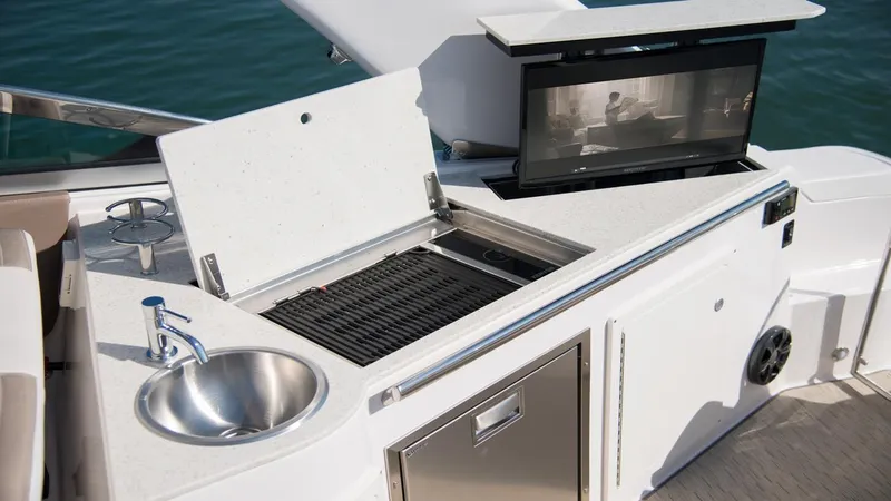 Slide: The Image of 2026 Regal 33 XO yacht outdoor kitchen with grill, sink, and storage. - 30