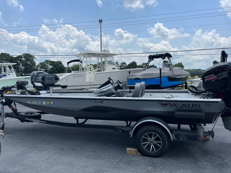 Slide: The Image of 2022 Vexus AVX189 boat on trailer, parked outdoors under a cloudy sky. - 0