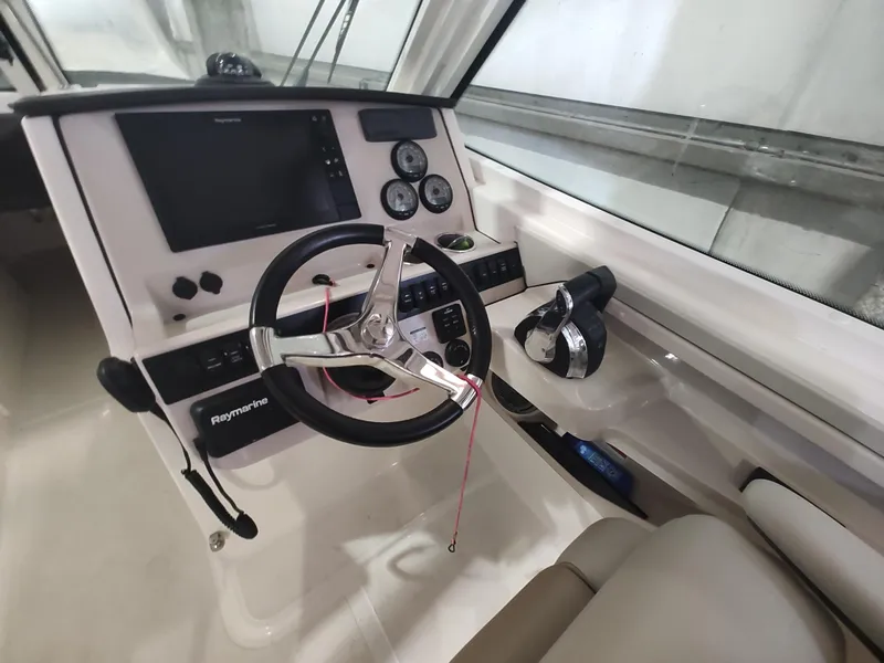 Slide: The Image of 2021 Boston Whaler 280 Vantage helm with steering wheel, controls, and navigation display. - 12