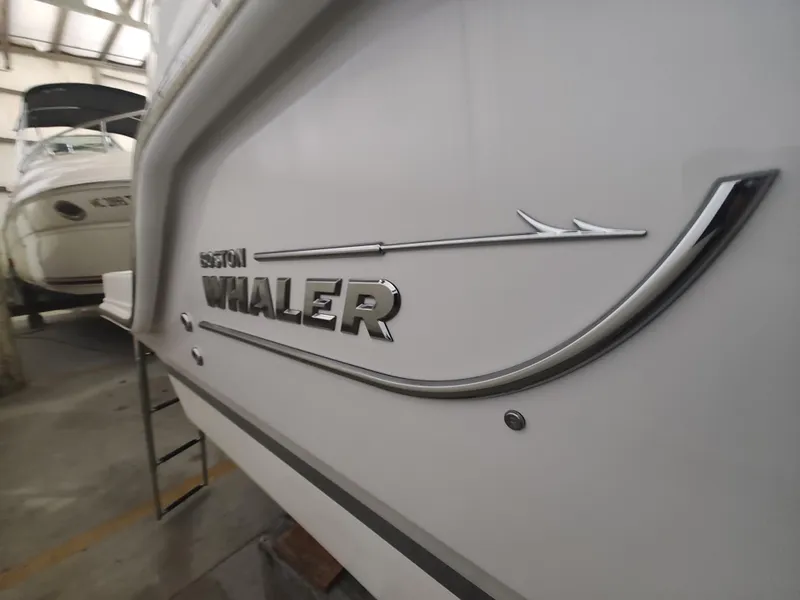Slide: The Image of 2021 Boston Whaler 280 Vantage boat in storage, showcasing sleek design and logo. - 20