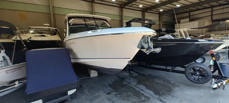 Slide: The Image of 2021 Boston Whaler 280 Vantage boat in a storage facility, surrounded by other boats. - 4