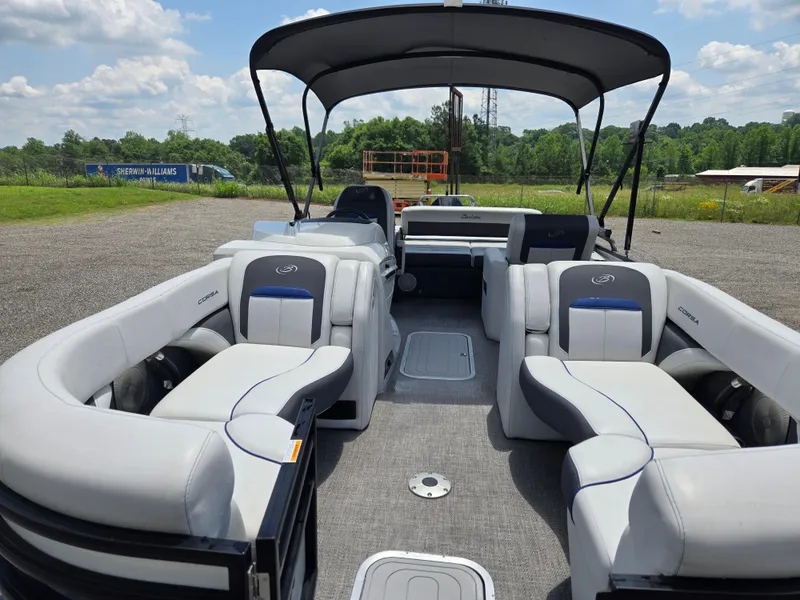 Slide: The Image of 2022 Barletta Corsa 23U pontoon boat with spacious seating and canopy, set outdoors. - 16
