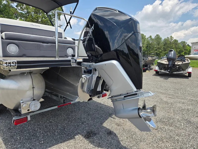 Slide: The Image of 2022 Barletta Corsa 23U pontoon boat with powerful outboard motor, parked outdoors. - 18