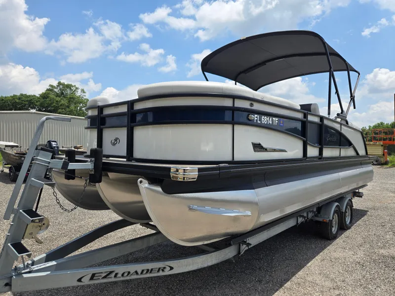 Slide: The Image of 2022 Barletta Corsa 23U pontoon boat on EZ Loader trailer, parked outdoors. - 24