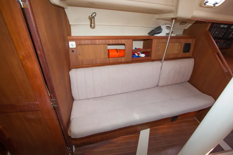 Slide: The Image of 1989 Hunter 37.5 sloop interior with cushioned seating and wooden cabinetry. - 12