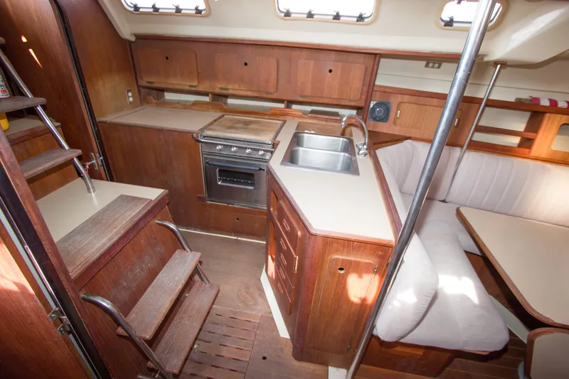 Slide: The Image of 1989 Hunter 37.5 sloop interior with kitchen, sink, stove, and seating area. - 13