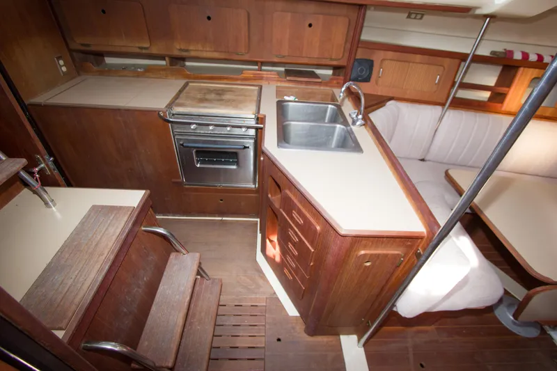 Slide: The Image of Interior of 1989 Hunter 37.5 sloop, featuring a compact kitchen with stove and sink. - 14