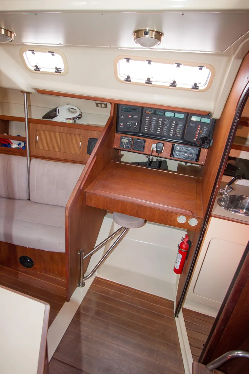 Slide: The Image of 1989 Hunter 37.5 sloop interior with navigation station, seating, and wooden finishes. - 15