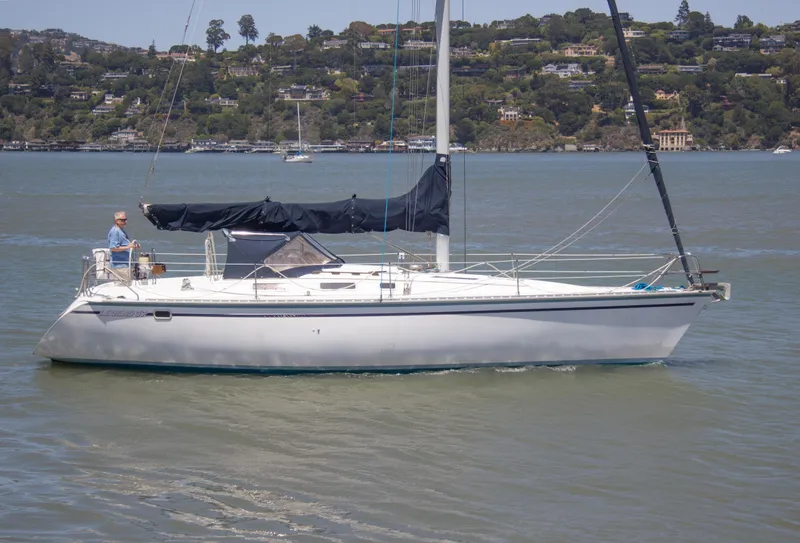 Slide: The Image of 1989 Hunter 37.5 sloop sailing on calm waters with scenic hillside background. - 2