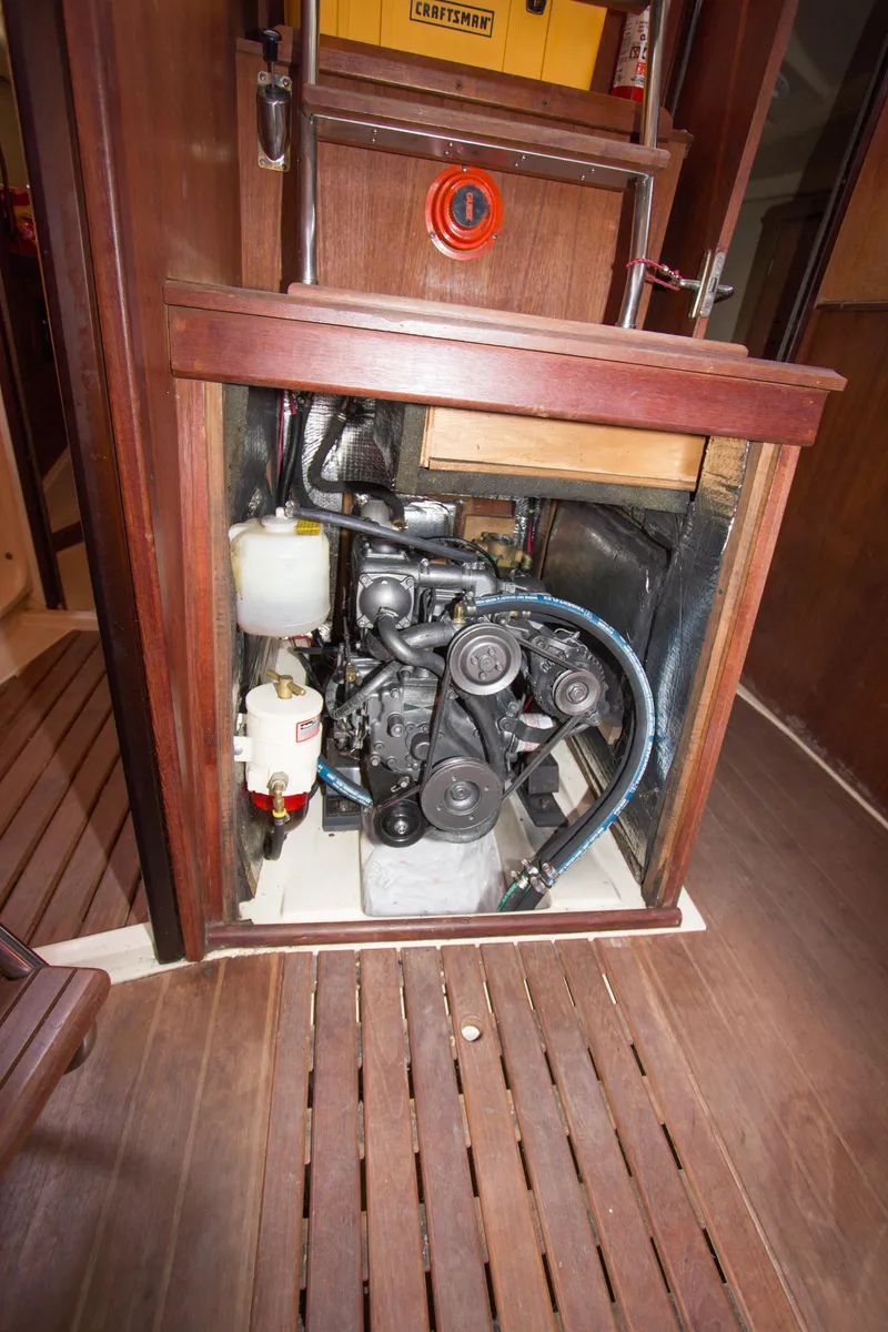 Slide: The Image of Engine compartment of 1989 Hunter 37.5 sloop, showcasing mechanical components and wooden interior. - 19