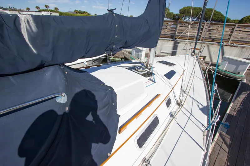 Slide: The Image of 1989 Hunter 37.5 sloop sailboat docked, featuring covered sails and clean deck. - 21
