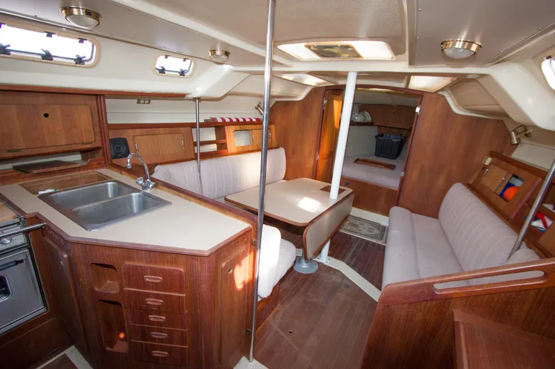 Slide: The Image of 1989 Hunter 37.5 sloop interior with wood finish, kitchen, and seating area. - 9