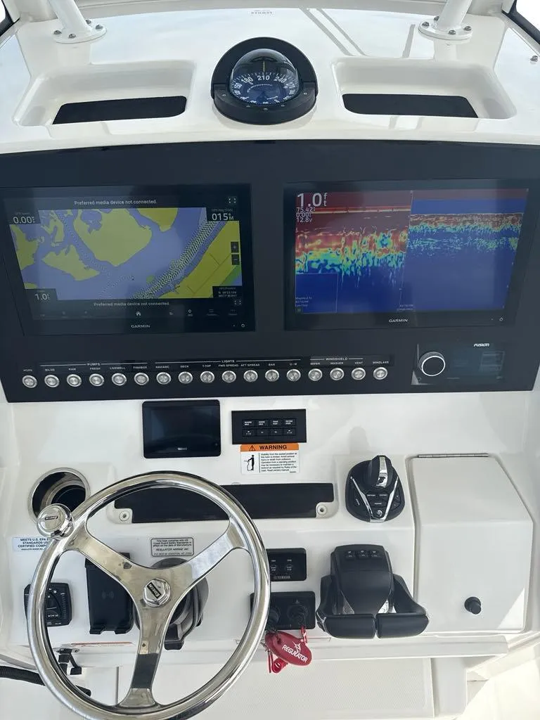 Slide: The Image of 2023 Regulator 28 boat dashboard with dual navigation screens and steering wheel. - 11