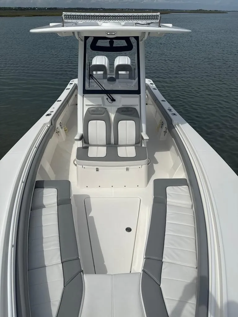 Slide: The Image of 2023 Regulator 28 boat with spacious seating and sleek design on calm water. - 13