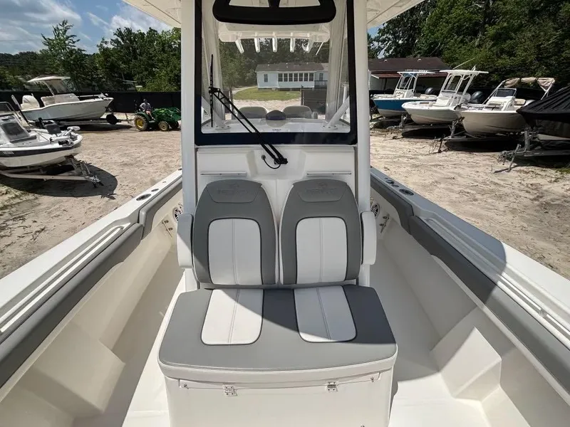 Slide: The Image of 2023 Regulator 28 boat interior with dual seats, parked among other boats. - 14