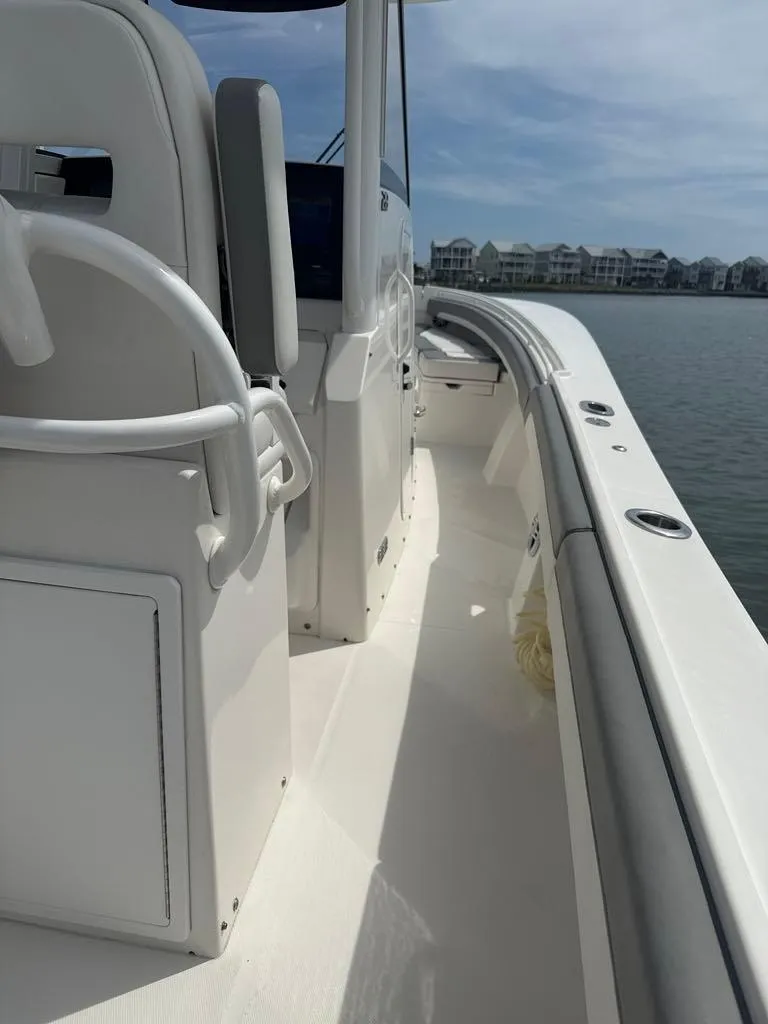 Slide: The Image of 2023 Regulator 28 boat deck with seating, on calm water, under a clear sky. - 18