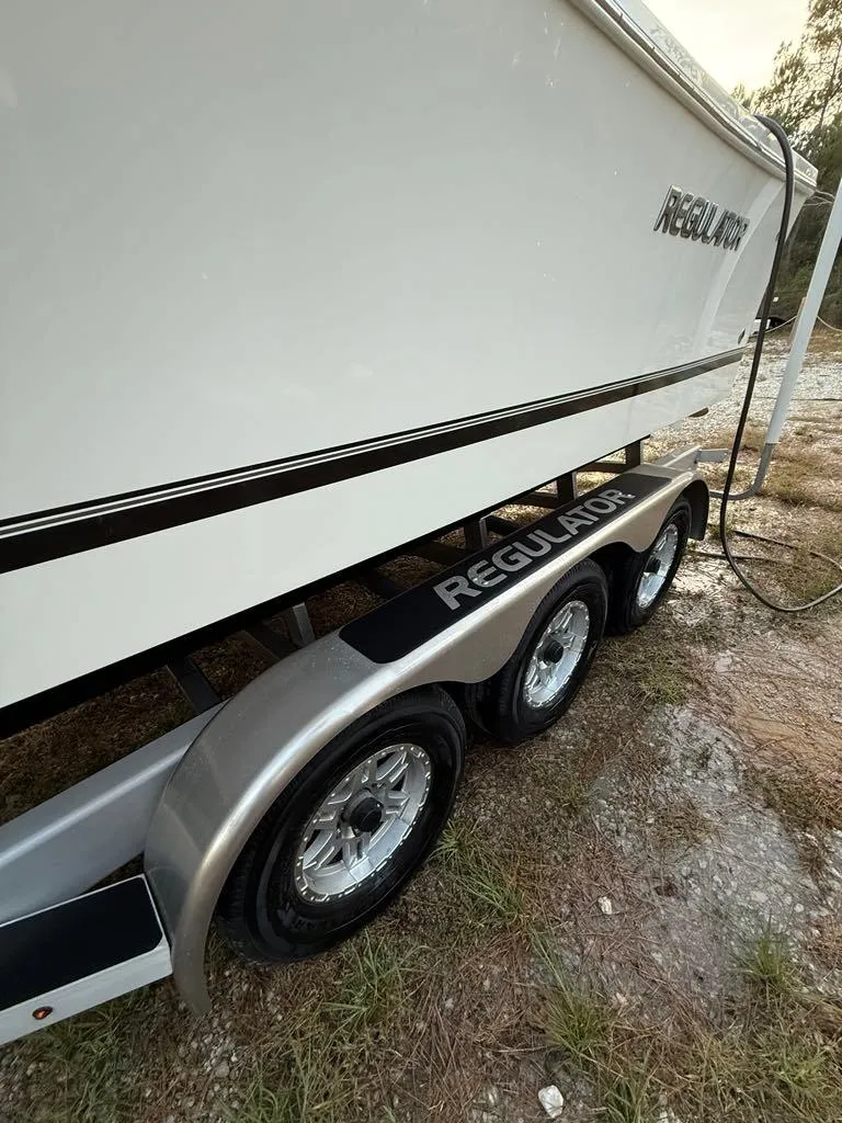 Slide: The Image of 2023 Regulator 28 boat on a triple-axle trailer, side view. - 21