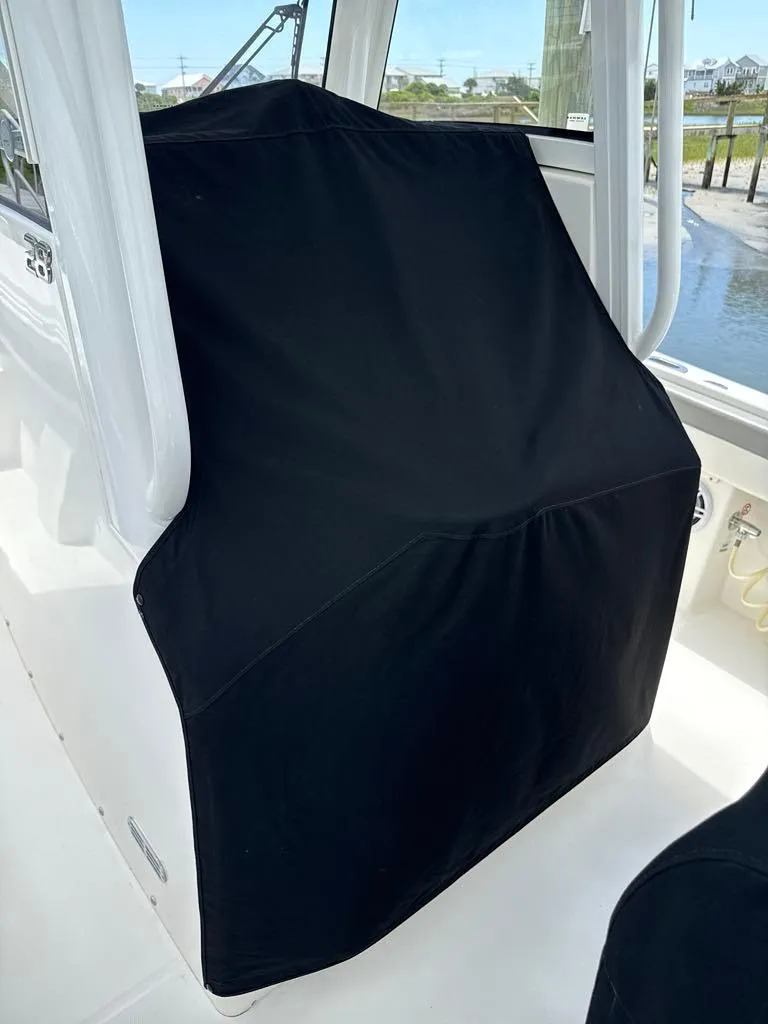Slide: The Image of 2023 Regulator 28 boat with black console cover, dockside view. - 24