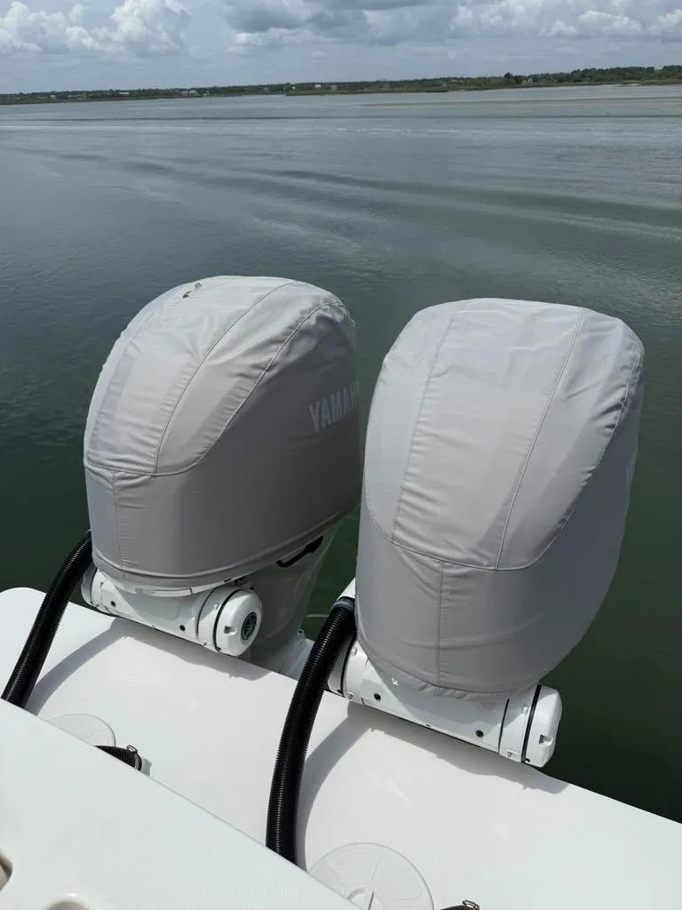 Slide: The Image of 2023 Regulator 28 boat with covered Yamaha outboard motors on calm water. - 25